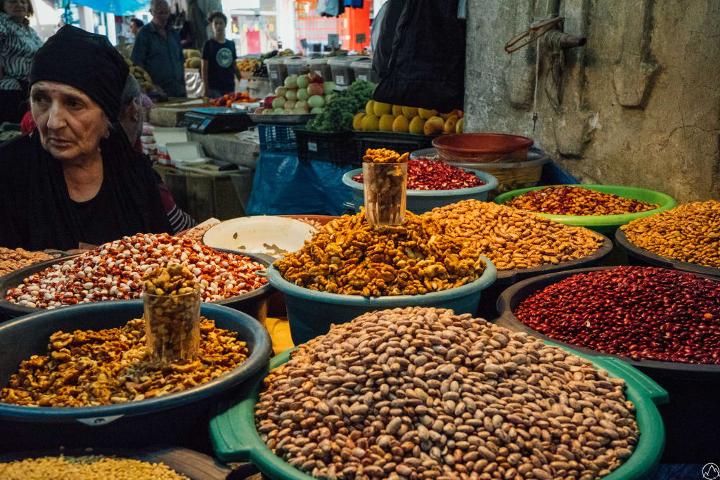 Bancarella di spezie e frutta secca in un mercato tradizionale georgiano.
